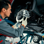 Car,Mechanic,Worker,Repairing,Suspension,Of,Lifted,Automobile,At,Auto